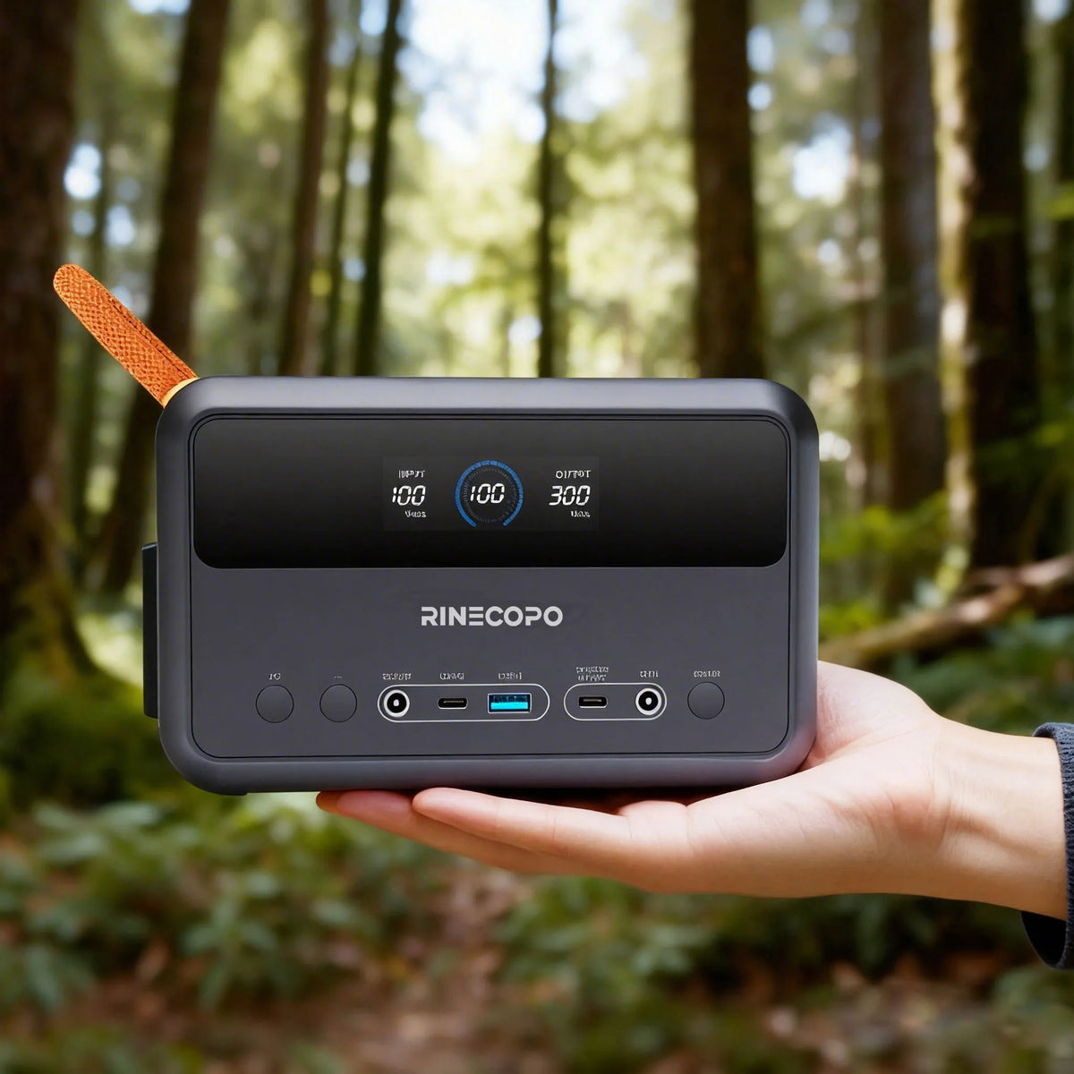 A person effortlessly holding the RINECOPO ultra-compact power station in one hand in a forest, demonstrating how easily it fits into backpacks for hiking and camping.