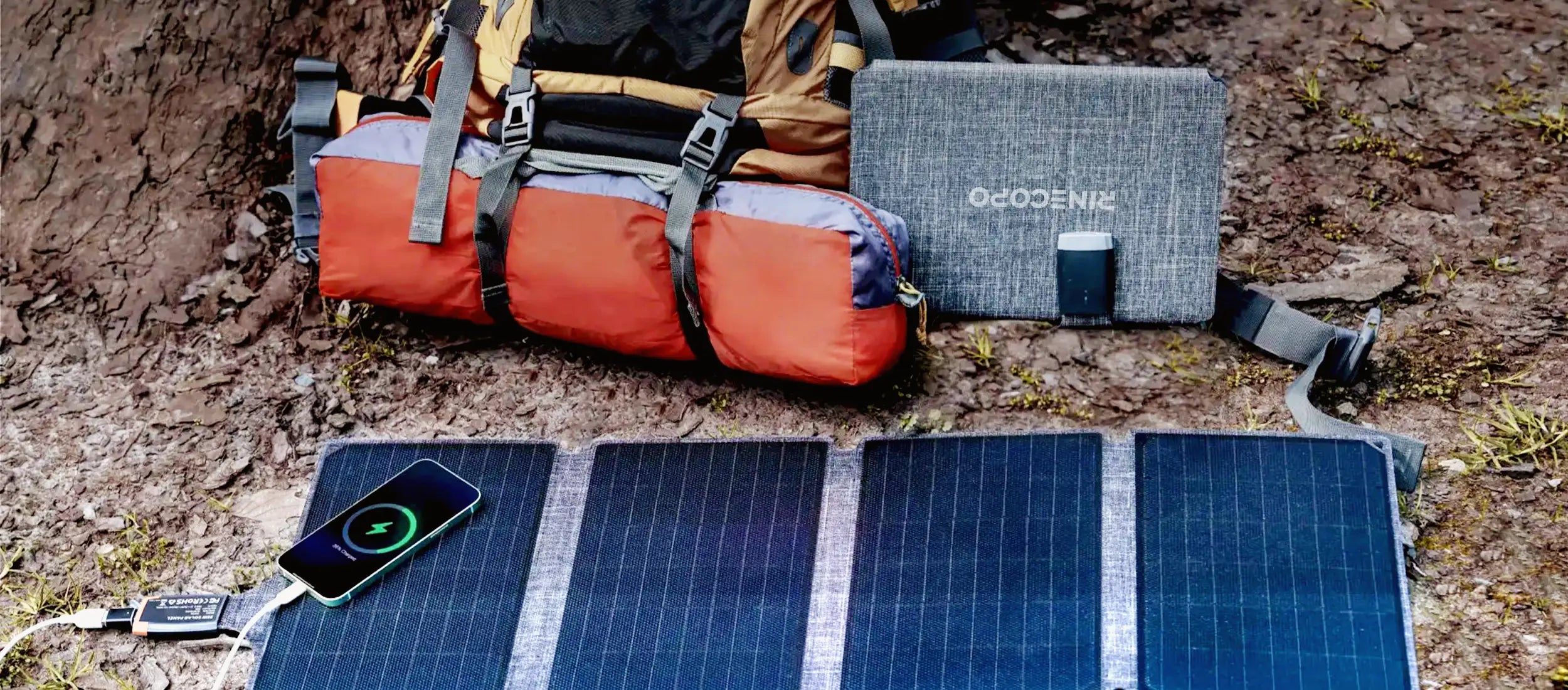A front view of the Rinecopo foldable solar panel in its closed, compact state. Featuring a durable fabric finish and integrated handle, this portable solar charger is designed for easy transport and space-saving storage for hiking and camping trips