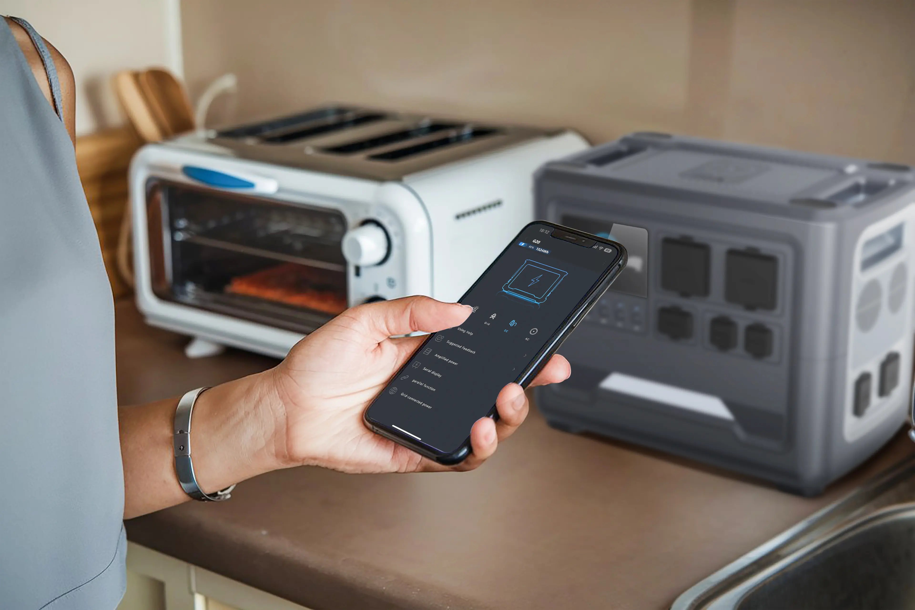 A user remotely monitoring a Rinecopo portable power station via a smartphone app while powering a kitchen oven. This smart energy management system allows real-time tracking of high-wattage power usage, perfect for home emergency backup and modern smart home integration