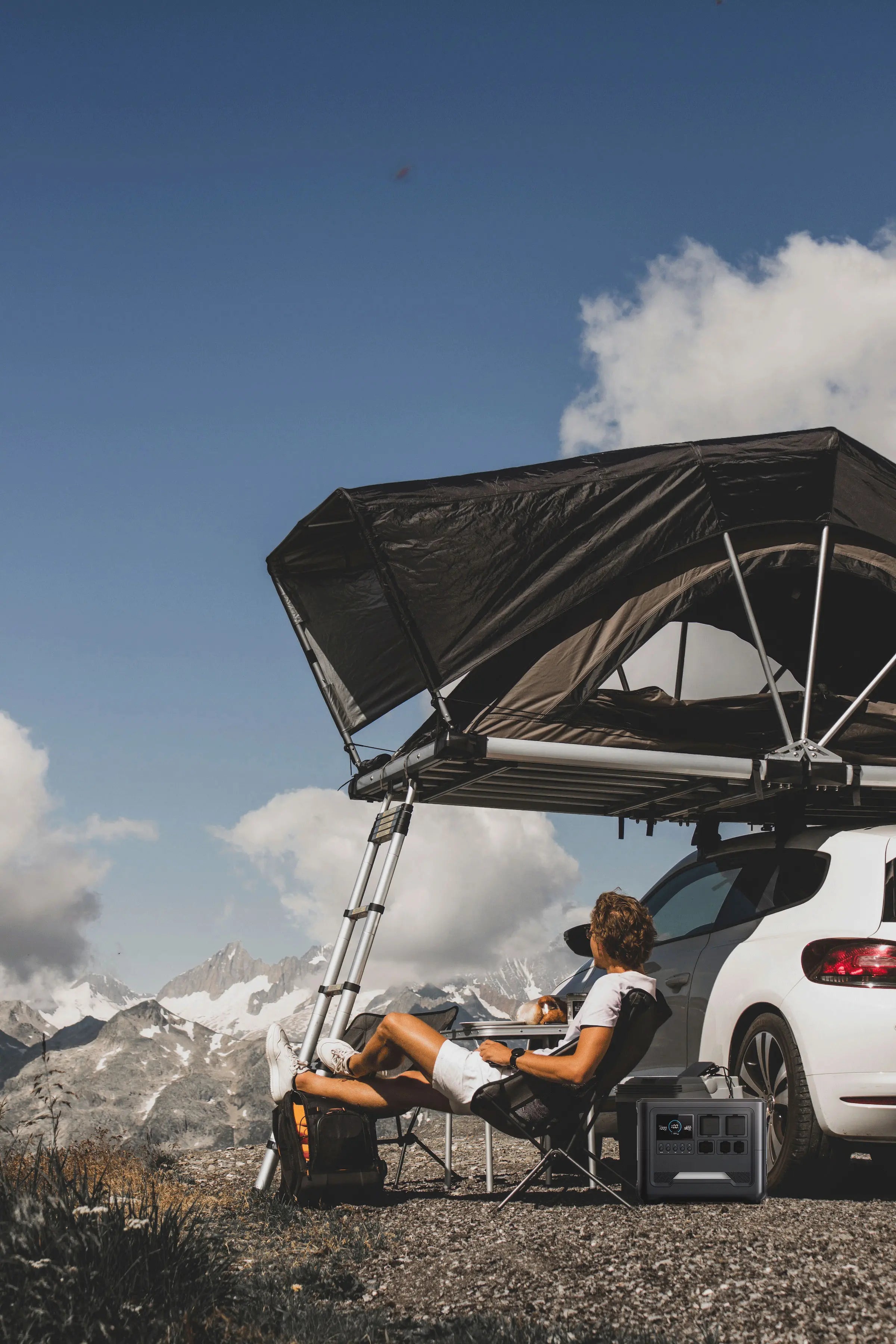 A traveler uses a Rinecopo high-capacity portable power station and foldable solar panels to power a miniature kitchen inside a rugged off-road camper van. The ultimate off-grid energy solution for Van Life, overlanding, and extended boondocking trips