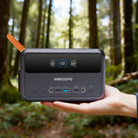 A person effortlessly holding the RINECOPO ultra-compact power station in one hand in a forest, demonstrating how easily it fits into backpacks for hiking and camping.